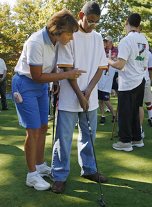 Golfer Sheila Drummond , who is blind, gives some putting advice to Jonathan Goodson, 13, a student from Overbrook School for the Blind.